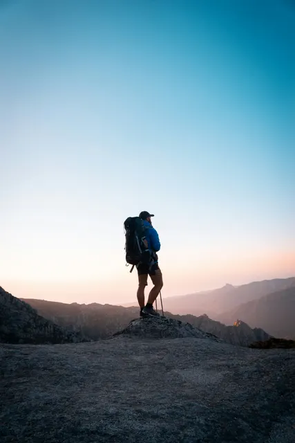 A trekker moving through a rocky mountain trail